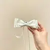Cetim dos sonhos, bolinhas gentis e etéreas, fitas com laços, presilhas de banana, coração feminino, toque de luxo, nuca, acessório de cabelo versátil