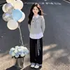 Conjunto de duas peças estilo colegial para meninas mais velhas, apresentando um top patchwork e calça casual xadrez com blocos de cor, um look versátil e moderno