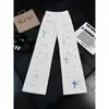 Calça jeans de luxo estilo americano com bordado cruzado e efeito desgastado, com patches de couro, calça longa versátil casual slim-fit para o dia a dia