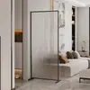 Simples e elegante, este biombo de vidro móvel com arco longo serve como divisória para a sala de estar, proporcionando privacidade e separando o hall de entrada da área do sofá.
