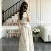 Conjunto de T-shirt cropped curta feminina de verão + saia longa floral, um look super moderno, conjunto completo para vendas transfronteiriças