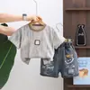 Roupas de Verão para Meninos de Comércio Exterior 2026, Novos Shorts Jeans Rasgados com Logo de Rosto Sorridente, Gola Redonda, Conjunto Elegante de Duas Peças com Manga Curta