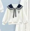Conjunto de duas peças estilo preppy para meninas para o início do outono: moletom estiloso com gola Peter Pan, laço e saia branca em camadas
