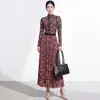 Conjunto de duas peças plissado estilo Miyake com estampa de leopardo, composto por um top justo de manga longa com gola semi-alta e uma saia plissada evasê de cintura alta