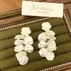 Pendientes de perla de camelia nuevos de primavera y verano pendientes de flor de temperamento para mujer pendientes de pétalos de lujo de alta gama venta al por mayor