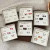 Otoño e Invierno Popular Pequeño Fresco Caja de Regalo de Pendientes de Una Semana Set para Mujer Aguja de Plata Pequeños Exquisitos Dulces Pendientes de Regalo Venta al por Mayor