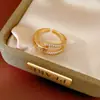 Anillo bañado en oro real de 18k con incrustaciones de circonita, diseño geométrico hueco, sensación de nicho de alta gama, accesorio de mano exquisito y elegante