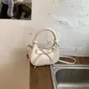 Bolso de media luna de nicho estilo coreano, bolso de mano nuevo de un solo color con lazo, bolso cruzado casual y moderno para mujer al por mayor