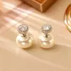 Um par de brincos brilhantes de zircônia e pérola com um design criativo, oferecendo um visual de alta qualidade, moderno e requintado, acessório popular online