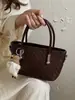 Bolsa de mão com padrão trançado de nicho altamente estilosa 2026 nova moda cor sólida chique para ombro e transversal atacado