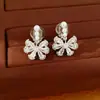 Pendientes de clip de flor de circonita cúbica chapados en oro de 18 quilates y nudo de mariposa con perla para mujer, no requieren perforación, pendientes ligeros y lujosos con un toque de alta gama