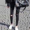Venta al por mayor de pantalones negros ajustados de sarga, ajustados y ajustados, para mujer, para primavera y otoño, pantalones finos rotos.