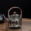 Tetera de vidrio de borosilicato resistente a altas temperaturas, venta al por mayor, estufa de cocina de té rodeada, tetera de cocina doméstica