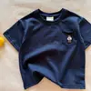Camiseta Infantil de Algodão Puro Manga Curta para Meninos Verão 2026 Novo Estilo Camiseta com Bolso Bordado de Urso para Bebês Cor Sólida para Meninas Fina