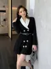 Elegante vestido de traje negro de doble botonadura con solapa y manga larga, una minifalda plisada chic y elegante para el trabajo
