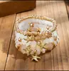 Pulseras multicapa al por mayor, juego de cuatro piezas de joyería con cuentas de artesanía en vidrio, juego de pulseras elásticas, accesorio de mano con soporte de flor de hierro