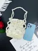 Elegante y versátil bolso de mujer 2025 nuevo modelo casual hecho a mano bolso de mano tejido hueco con cuentas plateadas