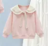 Conjunto de duas peças estilo preppy para meninas para o início do outono: moletom estiloso com gola Peter Pan, laço e saia branca em camadas
