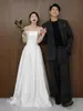 Vestido de noiva leve em cetim estilo francês com design ombro a ombro, simples e elegante, adequado para ensaios fotográficos de casais com tema de estúdio, vestido branco para passeios