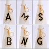 Llavero con colgante de aleación creativa con letras en inglés y gota de aceite de aleación con diamantes.