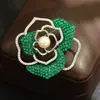 Broche de camelia de cristal de diamante cuadrado de tres colores (rojo, azul y verde) de lujo de alta gama con incrustación hueca y pasador de piedra rosa para mujer