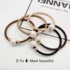 Nueva cuerda para el pelo simple de perlas, diadema, banda elástica, cuerda para la cabeza con cubierta de cuero para mujer, versión coreana de Banda Elástica al por mayor, anillo para el pelo de alta elasticidad