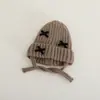 Gorro tejido para bebé con orejeras, nuevo estilo otoño/invierno, gorro de lana cálido con un lindo moño, a prueba de viento y adecuado para niños