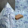 Tela jacquard floral de seda azul satinado y plateado con peonías para vestidos, ropa y materiales decorativos de diseñador