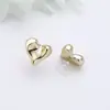 Pendientes versátiles de temperamento de alta gama estilo Hepburn de Instagram pendientes en forma de corazón pendientes de botón de corazón tridimensionales exquisitos a la moda simples