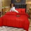Venta al por mayor del fabricante Juego de cuatro piezas de color sólido de lujo ligero Rojo brillante Sábanas de cama bordadas para bodas Funda de edredón Algodón lavado Ropa de cama cepillada