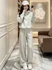 Moda estilo francés 2026 deportivo nuevo otoño e invierno casual moderno reductor de edad conjunto de dos piezas con sudadera con capucha y pantalones de pierna ancha