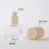 Material de empaque de vidrio de alta gama personalizado por el fabricante para cuidado de la piel, botella cilíndrica de 30 ml con fondo grueso para base líquida con cabeza de bomba