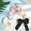 Llavero colgante de lazo de perlas en forma de corazón más vendido, muñeco de decoración de mochila con cinta colorida estilo Chanel pequeño personalizado