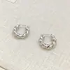 Nuevos pendientes versátiles de estilo europeo y americano, trenzados de doble hebra de cobre chapado en oro real, de lujo ligero, con un acabado brillante de alta gama para mujer