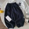 Calça Longa Infantil 2026 Outono Novidades Meninos e Meninas Calça de Moletom Estampada Bebê Estilo Coreano Cor Sólida Calça Longa com Punho na Barra Tendência