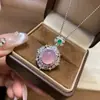 Pingente de calcedônia tipo gelo totalmente cravejado de diamantes para mulheres, apresentando uma vibrante pedra preciosa pequena olho de gato verde e branca, uma corrente delicada e uma corrente para clavícula, oferecendo um toque de luxo discreto.