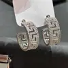 Brincos em forma de C com diamantes inteiros e padrões intrincados no estilo nicho de Cao Shi, oferecendo uma sensação de luxo leve e de alta qualidade, versáteis para o uso diário, disponíveis para dropshipping