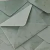 Sobre de terciopelo marrón oscuro con logo de marca estampado en dorado, tarjeta acrílica de borde dorado irregular, invitación de negocios