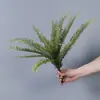Plantas verdes artificiales en stock, manojos de helecho, hojas de helecho, hierba de helecho para decoración de paredes interiores y diseño de paisajes, césped artificial al por mayor