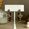 Aretes de aro negros con patrón de cruz estilo court vintage, aretes empalmados estilo mediados de siglo, lujo ligero con un toque de alta gama, aretes elegantes para mujer
