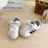 Zapatillas deportivas para niños 2026 nuevo modelo de otoño zapatillas para niñas puntera de concha zapatillas de entrenamiento alemanas zapatillas de moda para niños versión coreana