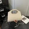 Elegante y chic bolso cruzado de un solo hombro con un diseño minimalista, un nuevo modelo para el verano de 2026, con una textura tejida y una forma cuadrada pequeña, perfecto para mujeres