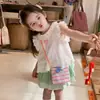 Traje Doce de Verão 2026 para Meninas: Camisa de Boneca Branca Bordada em Desenho Animado com Saia Verde Estilosa