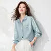Nova Camisa de Cor Sólida com Manga Longa para a Primavera de 2026 Estilo Coreano Simples Gola Reversível Fechamento em Botão Único Bolso Bordado Top Versátil para Mulheres