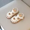 Sapatos de couro respiráveis com design vazado estilo coreano para crianças, novos modelos de sandálias de verão 2026 para meninas, bico fechado, sola macia, sapatos de bebê.