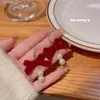 Brincos vermelhos estilo Hong Kong para o Ano Novo Chinês feminino pelúcia vermelho arco pérola Ano Novo brincos de gancho de orelha atacado