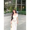 Vestido branco ombro a ombro estilo francês para mulheres, novo conjunto de roupa para o início do verão 2026, elegante vestido longo acinturado