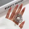 Anillo abierto de estilo dulce y fresco con personalidad de perla de imitación de metal con pliegues de viento exagerados entre Europa y Estados Unidos.