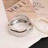 Pulsera personalizada de aleación irregular Pulsera transfronteriza europea y americana Pulsera de versión ancha de superficie brillante de lujo ligero con resorte