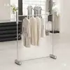 Expositor de tienda de ropa de pie de acero inoxidable isla negra barra colgante plateada estanterías para tienda de ropa de mujer expositor